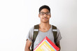 © Oleksandr - Happy afro american student in glasses with books. Portrait of a black young man with textbooks in his hands. Smiling boy with a backpack and notebooks on a white background.