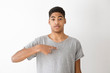 © Oleksandr - You to me ? Who am I ? African-American boy inquiringly points to himself with a finger. Black young man looks surprised. Teenager with an uncertain facial expression.