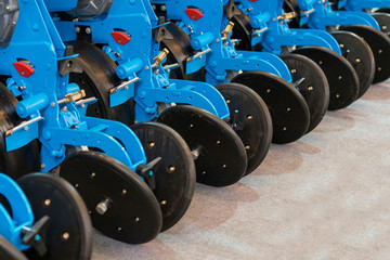 Wall Mural - Corn harvester head with several silver blades. Agricultural machinery for soil cultivation. Agricultural machinery planter in the garage closed for storage until the next season