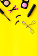 © 9dreamstudio - make up set with woman decorative cosmetic with eye shadows and mascara on yellow background top view space for text