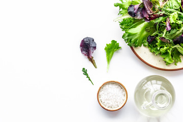 fitness food cooking with green and red salad mix on white background top view copyspace