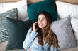 © BestForYou - Happy woman talking on phone in the bed at home.