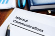 Stack of internal communications documents on a table.