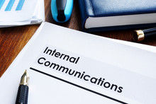 Stack Of Internal Communications Documents On A Table.