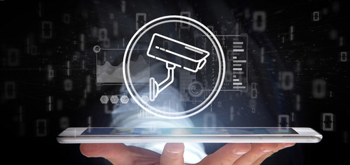 Poster - Businessman holding Security camera system icon and statistics data - 3d rendering