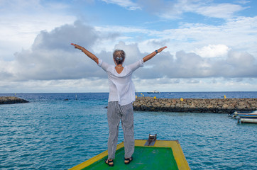  girl costs by the boat with the raised hands happiness