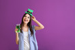 © Pixel-Shot - Beautiful young woman with green hat and glass of beer on color background. St. Patrick's Day celebration