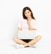 © Tom Wang - Happy young woman sitting on the floor using laptop