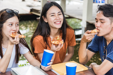 Wall Mural - Students group woman and man eating pizza together