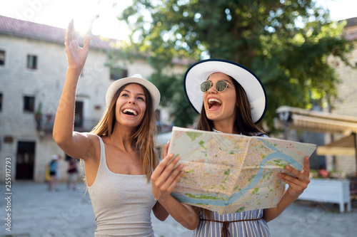 Cuadros en Lienzo Young happy tourists women sightseeing in city on vacation