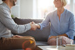 © Seventyfour - Successful counselor shaking hand of mature female patient while both sitting on couch after consultation