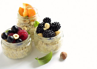 Wall Mural - Oat flakes with various berries, hazelnuts and honey in glass jars,  copy space