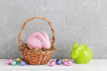 Two rabbits and traditional Easter basket with eggs.