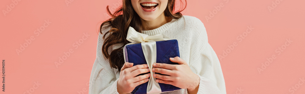 cropped view of woman in white sweater holding gift box isolated on pink - obrazy, fototapety, plakaty 