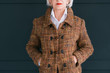 © golubovy - Trendy senior wardrobe. Female style and elegance. Aged lady posing in fashion tweed autumn outfit with hands in pockets.