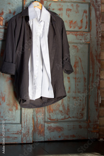 White And Black Shirts On Hanger Against Grunge Wooden Door Male