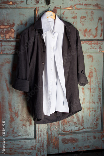 White And Black Shirts On Hanger Against Grunge Wooden Door Male
