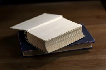 Fototapete - An open old retro book with white blank empty pages on which the designer can write a greeting text or a postcard on the wooden background of the library atmosphere