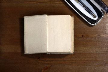 Fototapete - Open old retro book with blank empty pages next to pen with free copy space for text background of the library atmosphere
