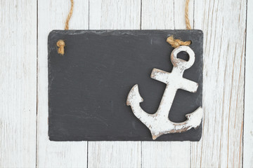 Canvas Print - Blank hanging chalkboard with anchor on weathered whitewash textured wood background