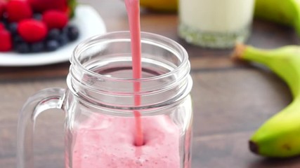 Wall Mural - Pouring mango and strawberries milk smoothie in jar