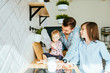 © Iryna - Joyful father and his cute toddler daughter and preteen son get ready to plaing and cooking at kitchen.
