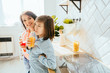 © Iryna - Happy mother and son having breakfast in kitchen at home in the sunny morning.