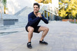 © Drobot Dean - Smiling young sportsman doing squats