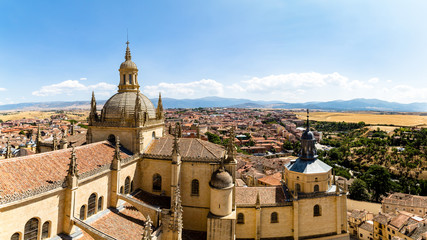 Wall Mural - Segovia, Spain – Panoramic 16:9 view of the dome of the Cathedral and of Segovia old town from the top of the bell tower during Summer time. The peaks of Sierra de Guadarrama are visible behind