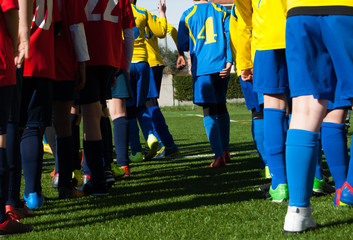 Legs of two teams of soccer children