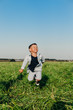 © Elena Kratovich - Happy little boy jumping on grass in summer sunny day
