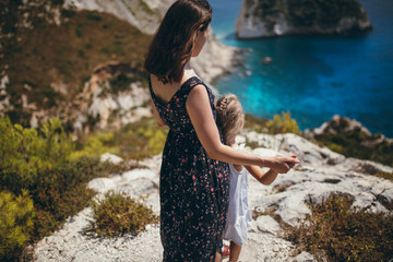 Mother and daughter standing at the edge of the cliff