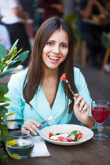 Canvas Print - Young beautiful woman is having breakfast in a cafe