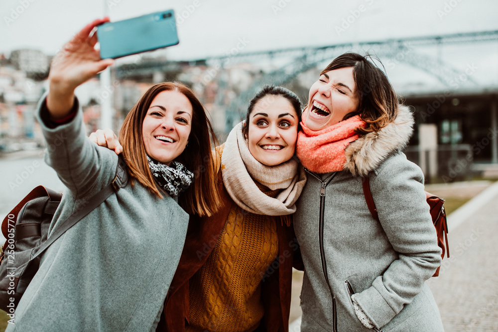 Photo Stock .Three beautiful and funny women traveling together in Porto, Portugal. Taking photos as memories of their trip, carefree and relaxed. Lifestyle. Travel photography | Adobe Stock