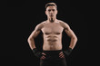 © LIGHTFIELD STUDIOS - strong muscular sportsman looking at camera with hands on hips isolated on black