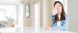 © Krakenimages.com - Wide angle picture of beautiful young woman sitting on white table at home doing stop sing with palm of the hand. Warning expression with negative and serious gesture on the face.