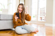 © Krakenimages.com - Beautiful young girl kid sending a message using smartphone very happy and excited, winner expression celebrating victory screaming with big smile and raised hands