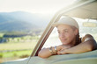 © Natalie Faye - Young woman wears baseball cap and leans out car window