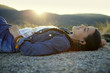 © Natalie Faye - Young woman in jean jacket relaxes on gravel
