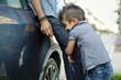 © Natalie Faye - Young boy with mohawk hugs father's leg