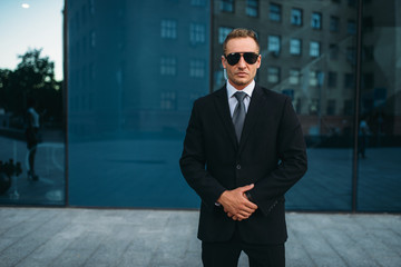 Wall Mural - Male bodyguard in suit, earpiece and sunglasses