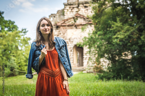 Fotomural junge Frau vor Ruine / Burg mit kraftvoller Pose