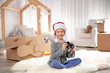 © New Africa - Cute little girl playing with binoculars and cardboard airplane in bedroom