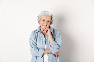 Canvas Print - Portrait of grandmother in stylish clothes on light background