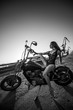 © Михаил Решетников - Red-haired woman in sexy lingerie in high heels sits on a motorcycle. Attractive red-haired girl sits on a motorcycle at sunset on the background of the industrial landscape