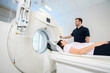 Computertomographie Untersuchung in der Radiologie, Patientin auf Untersuchungstisch, Untersuchung wird von MTRA vorbereitet