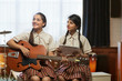 © IndiaPix - Two happy teenage school girls learning to play guitar in the music room at school