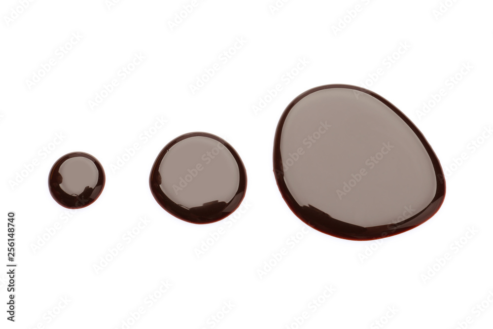 Drops of chocolate sauce on white background