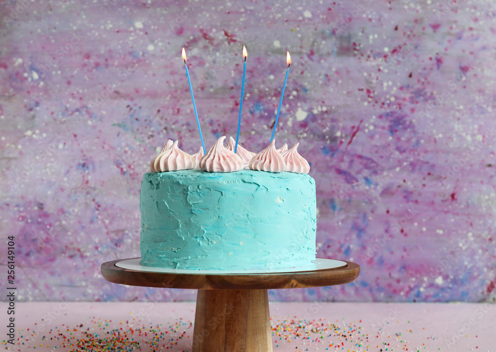 Tasty Birthday cake on table against color background