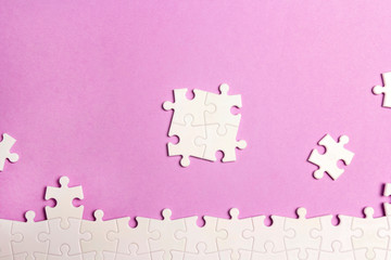 White puzzle pieces on a violet background.